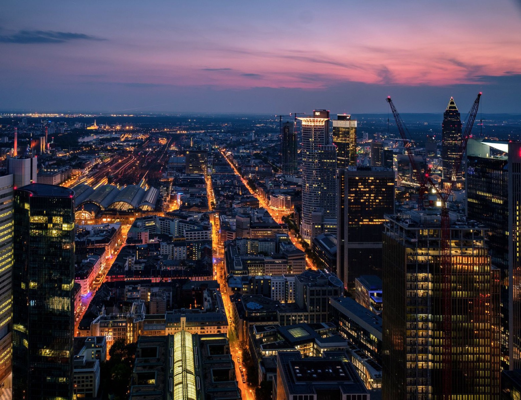 Blick über das Frankfurter Bankenviertel und den Hauptbahnhof in der Abenddämmerung
