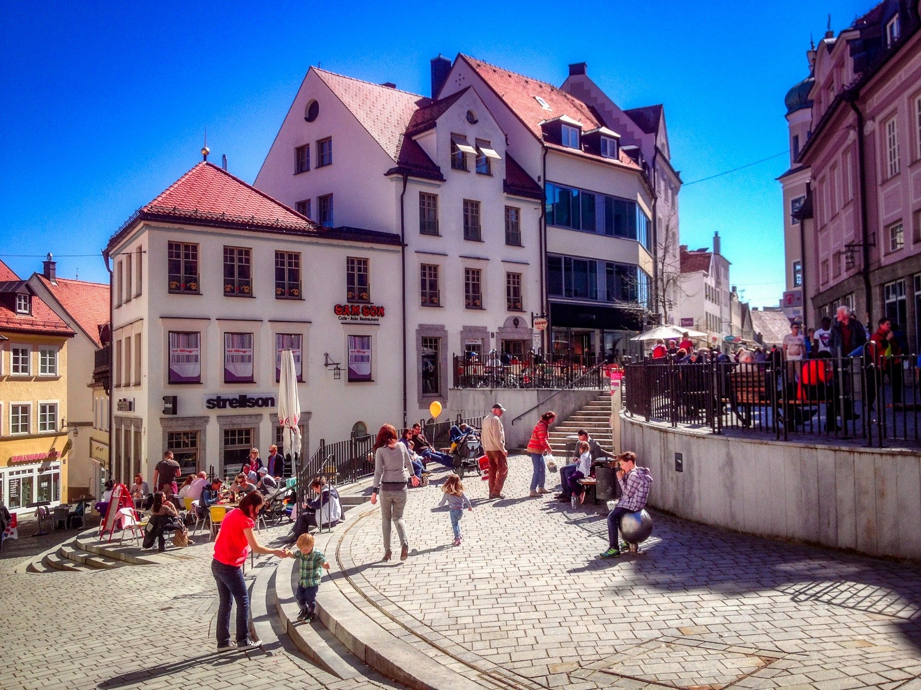Platz in der Kemptener Altstadt mit Bürgerhäusern und Passanten