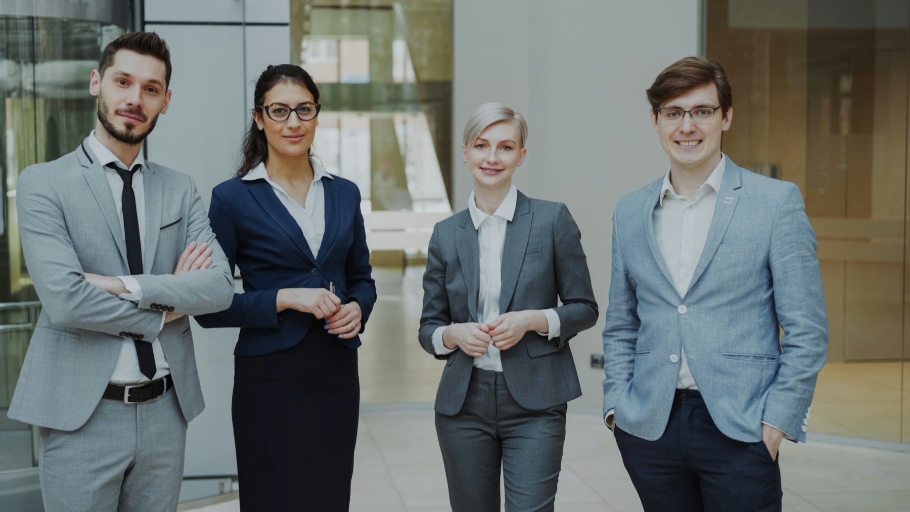 Vier Personen in Businesskleidung stehen nebeneinander